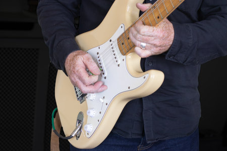 Close up of man playing an electric guitar with a green picの写真素材