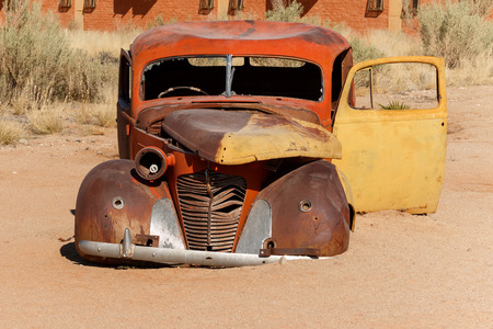 An old car wreck lying in the desert  Rusty but body is till intact の写真素材
