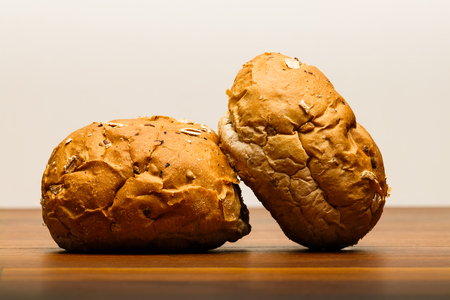 Two spelt buns on wooden surface. Spelt is also known as dinkel or hulled wheat. Spelt is an old specie of wheat which is very healthy and tasty.の写真素材