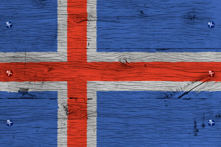 Iceland national flag. Painting is colorful on wood of old train carriage. Fastened by screws or bolts.の写真素材