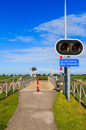 Bycicle bridge crossing Reitdiep river in Groningen, the Netherlands. With warning sign and lights.の写真素材