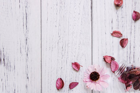 Flat lay stock photography vintage white painted wood floor purple flower petals and glass bottleの写真素材