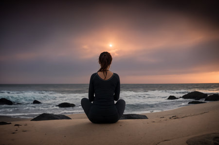 Backlit of a woman meditation on the beachの素材