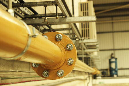Industrial yellow steel gas pipe close up where two pipes join の写真素材
