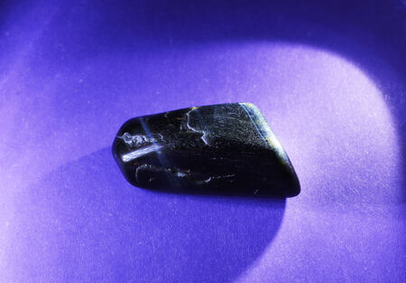 Hawkeye gemstone close up on a purple background の写真素材