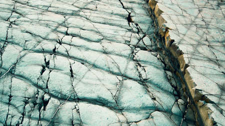 Cracked rock face along the Cornish coast, displaying striking patterns on the natural formation due...
