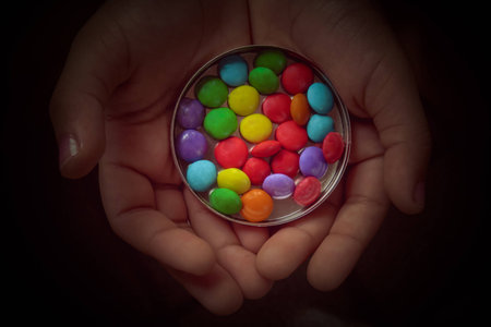 Child offering candy coloredの写真素材