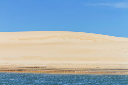 View of the dunes on the deserted beach with blue sky in the backgroundの写真素材