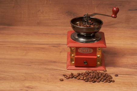 Manual coffee grinder for grinding coffee beans on a wooden surfaceの写真素材
