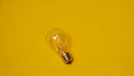 Transparent led light bulb on yellow backgroundの写真素材