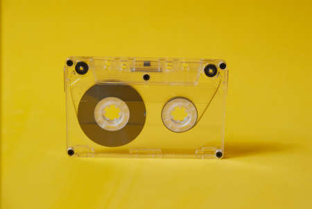 One transparent audio cassette on a yellow backgroundの写真素材