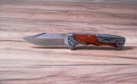 Hunting knife on a wooden background made of high quality stainless steel.