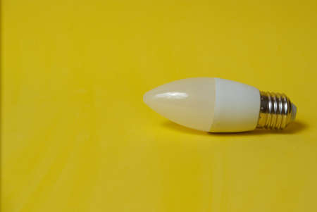 White led light bulb on yellow backgroundの写真素材