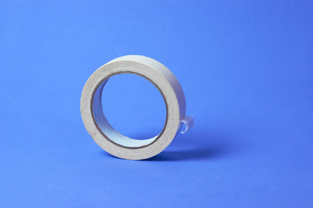 Roll of white tape on a bright blue backgroundの写真素材