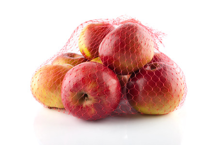 The heap of apples packaged in the red netの写真素材