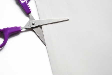 The scissor is cutting an envelope on the white backgroundの写真素材