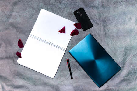 Flat-lay open note book with a mobile, pen and a Lap topの写真素材