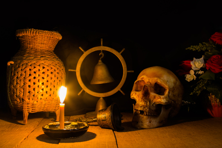 Awesome pile of skull on a brown wooden plank background and wooden bell. Still life style or selective focus and adjustment color for background.の写真素材