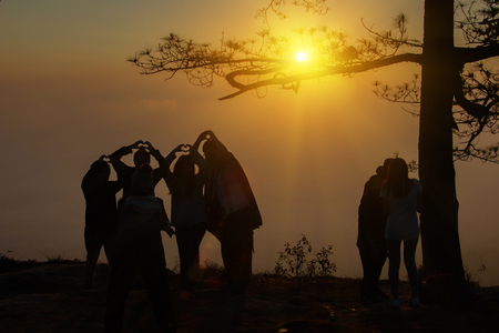 Vintage style of abstract blur field on orange bokeh light autumn at mountain and tree young photographer looking at scenery during golden hour sun rise background. Travel and Summer holiday concept.の写真素材