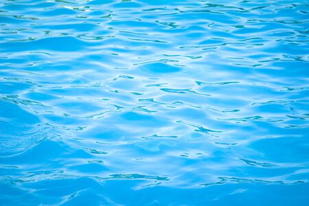 Surface of blue swimming pool background of water in swimming pool. Simulate natural wave ocean water texture summer or abstract blue sea water with white foam for copy space, nature concept.の写真素材