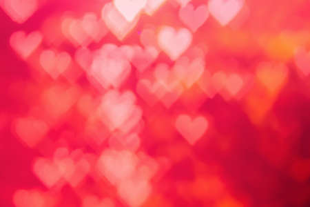 Red heat passionate and glamour bright bokeh background.Heart shaped bokeh red abstract background banner.  Love theme illustration. Valentines day concept. Copy space. Decorative glitter design.の写真素材