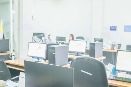 Business woman blur in the workplace at sitting with desk computer screen work space of table in office workers, interior modern design, people with document and laptop.の写真素材
