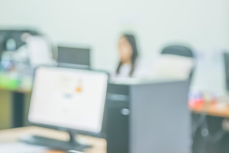 Business woman blur in the workplace at sitting with desk computer screen work space of table in office interior design, people with document and laptop depth abstract background.の写真素材