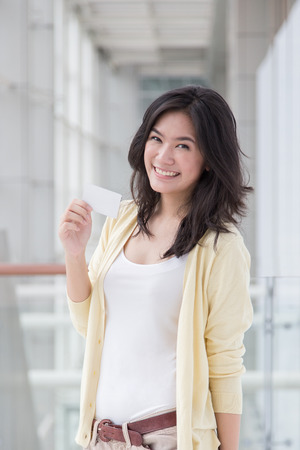 Asian woman holding a card in her hand