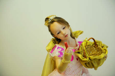 A girl in an elegant ball gown with the inscription alphabet and a gold basket in her hands on a...