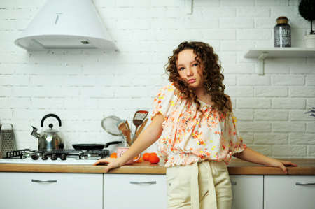 curly chic girl looks languid gaze mouth slightly open on her pink top with feathers of the eye a little with an oriental cut and hair light brown face and close-up hairstyleの写真素材