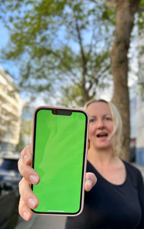 Teenage girl with loose hair brown hair brown hair dances with phone rejoices on the screen of...