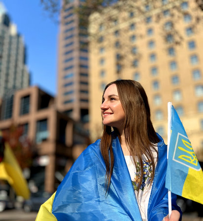 End of the war Ukrainian woman in a national shirt lays out the Ukrainian flag she shows it and is very happy about the victory of Ukraine over Russian terror she can return home with emigrationの写真素材