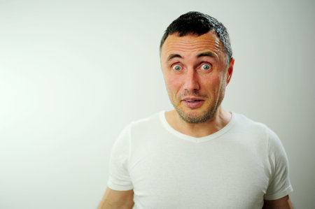 attractive unshaven man astonished amazed in shock surprise face expression and shock emotion Blue...