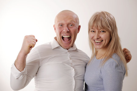 Loud sincere laughter man and woman in blue looking at the camera They open their mouths wide and laugh then look at each other and talk slow motion adults 50-55 Joy happiness success funny comedyの写真素材