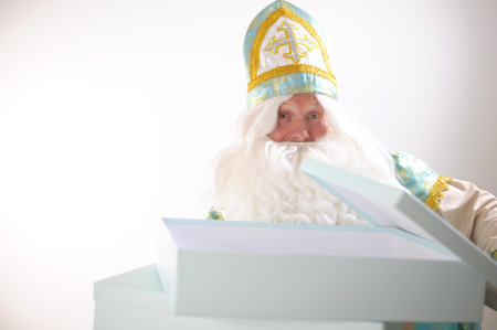 New Year is coming Saint Nicholas opened a large blue box, it is empty, there is a gift in it Sinterklaas portrait USA on a white background. Dutch Santa Claus St Nicholas christmas new yearの写真素材