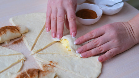 Female Hands Rolling Dough into Rolls Baking Process Making Croissant Bakery process of cooking...