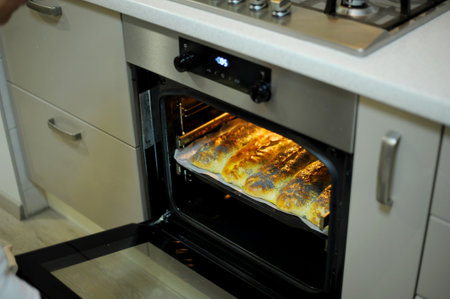 homemade pie sprinkled with poppy is prepared and baked in a special baking dish in oven in kitchen....