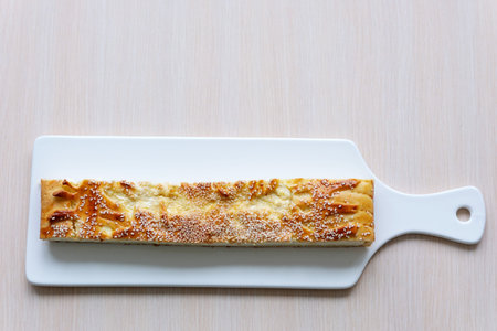 white porcelain cutting board large piece of pie strudel with cottage cheese soft pink table...