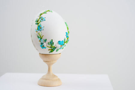Easter holiday on stand is white egg with blue embroidery cornflowers delicate flowers embroidery...