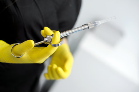 carpulse syringe Female doctor hands yellow gloves special instruments used in dentistry for local...