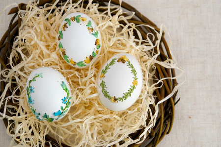 banner a lot of space for text coffee background Easter eggs decorated with painted embroidery ribbons on eggshell in nest three white eggs then on shavings advertising invitation postcard bigboardの写真素材