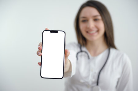 Portrait Of Happy Young Female Doctor Showing Cellphoneの写真素材