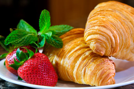 beautiful chic video on white plate two croissants huge strawberry and mint leaves filming delicious french breakfast restaurant serving fresh pastries unreal beautifully chic and tasty invite guestsの写真素材