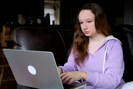 Hispanic latin girl college student using laptop computer watching distance online learning seminar class, remote university webinar or having virtual classroom meeting in university creative space.の写真素材