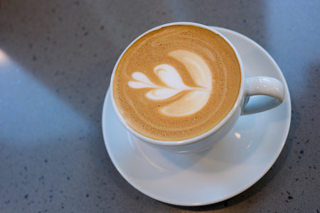 a cup of capuccino coffee flower pattern from aboveの写真素材