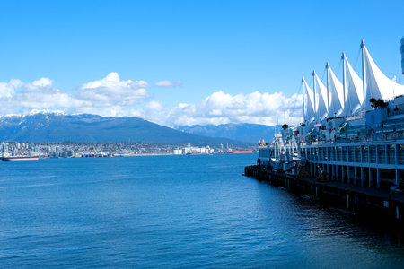 Canada Place view of office buildings and restaurants in the center of Canada Place white sails against the blue sky and white clouds slightly overexposed blue videoのeditorial素材