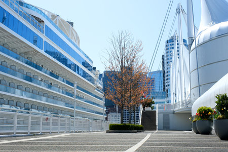 slow motion video filming blue sky Pacific Ocean large cruise liner stands off coast of Canada Place port for large ships windows many floors people sailing tourists vacation on luxury trips Canadaの写真素材