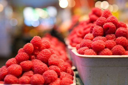 A full bowl of large raspberries Raspberries in wooden small box on the background embroider...