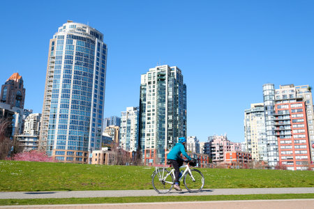 David Lam Park spring in big city cherry blossoms skyscrapers strolling pedestrians Pacific Ocean ships all this in several videos that can make good movie geese cyclists families women and menのeditorial素材