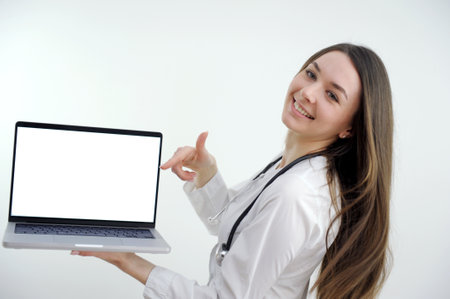 Happy doctor holding empty blank in hands. Female doctor showing a clipboard with blank paper. Close-up of a female doctor with lab coat and holding blank clipboardの写真素材